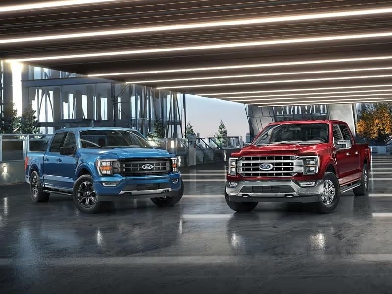 A red and blue Ford F-150 parked inside a garage